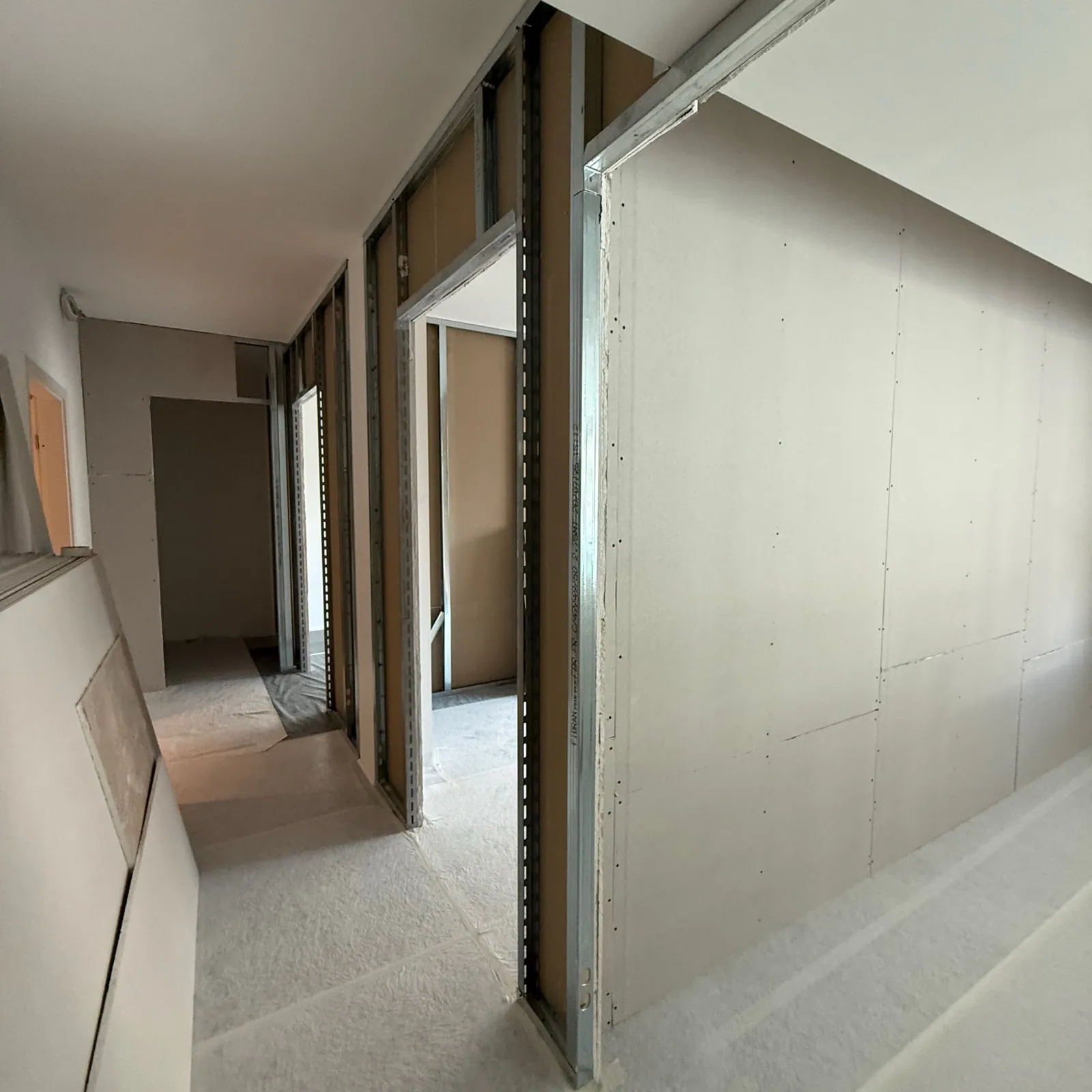 Sonnex 21 : cloisons en plaques de plâtre en cours de pose dans un couloir